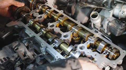 Mechanics hands install camshaft into engine. Process of reassembling engine Stock Footage 325521407