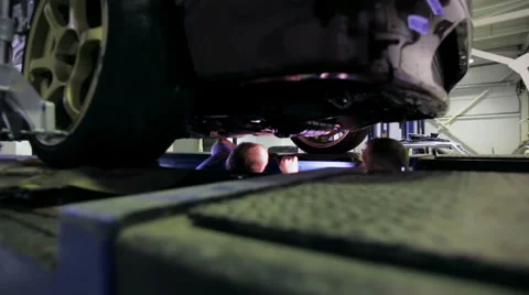 Mechanics inspect the machine driveshaft Stock Footage 67948917