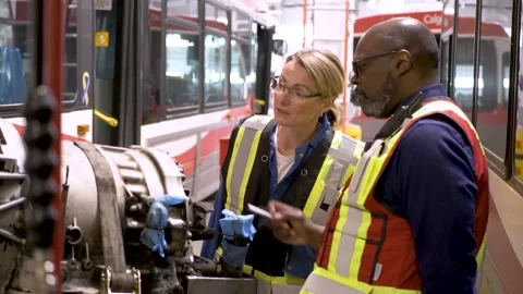 Mechanics inspecting bus engine in maintenance facility Stock Footage 221035707