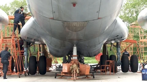 Mechanics perform maintenance on left main chassis Il-76 transport aircraft Video stock 108700344
