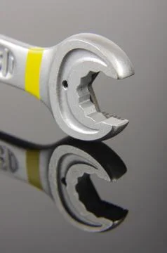 Mechanics spanner macro close up isolated on the black reflective surface Stock Photos