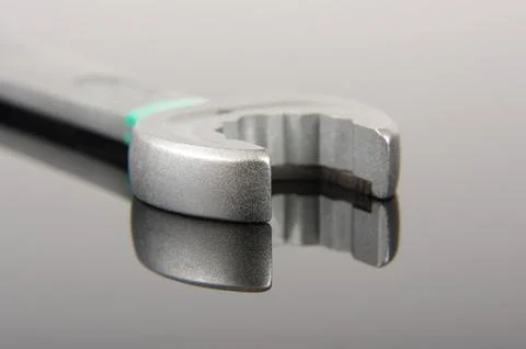 Mechanics spanner macro close up isolated on the black reflective surface Stock Photos