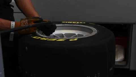 Mechanics at work on Pirelli slick racing tire in workshop Stock Footage 156508765