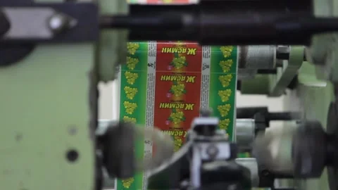 The mechanism of the packaging machine packages the candy bars in the paper. Stock Footage 128643144