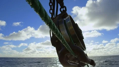 Mechanized fishing winch pulling thick green rope out of water, USA Stock Footage 138889509