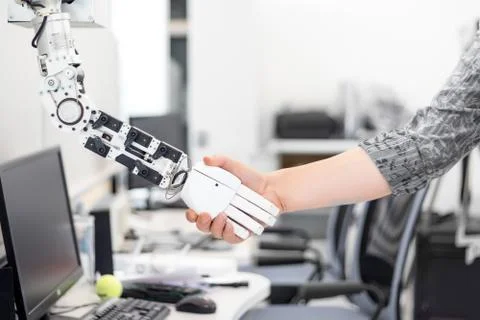 Mechanized robot hand holds the objects drawn to a man's hand shaking hands Stock Photos