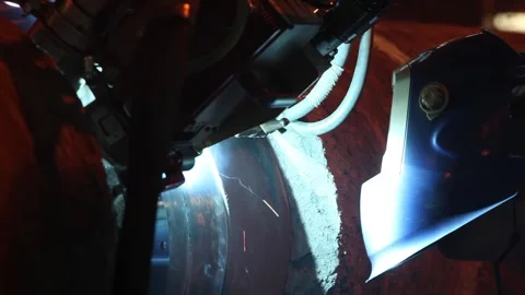 Mechanized Welding Head and Operator Shield Beside Large Steel Pipe Joint Stock Footage 341651919