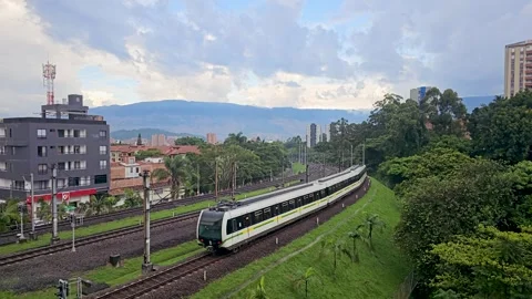 Medellin Metro Train Passing through Green Hills Stock Footage 286381043