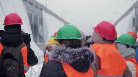 Media in work helmet and reflective vest at plant Stock Footage 70939959