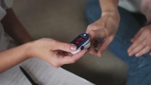 Medic and patient using finger pulse oximeter. Close-up Stock Footage 152328970