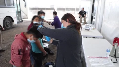 Medic checking child migrants heads at processing facility in Donna Texas Stock-Footage 151251822