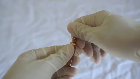A medic in gloves breaks off the edge of a glass ampoule. Stock Footage 322205902