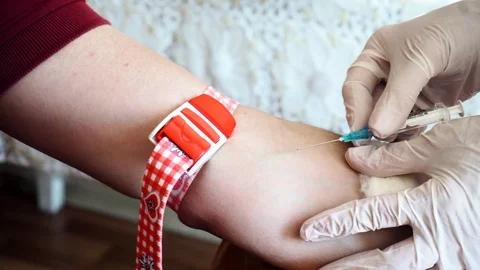 Medic in gloves puts needle in mans vein and connect test tube for blood Stock Footage 91067060