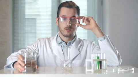 Medic pouring liquid from beaker to flask Stock-Footage 73111179