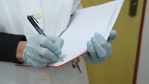Medic in rubber gloves writes in notebook Stock Footage 149353457
