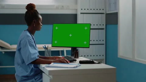 Medical assistant using horizontal green screen on computer Stock Footage 163427821
