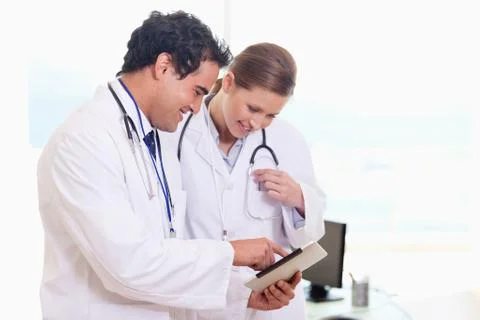 Medical assistants looking at clip board Stock Photos