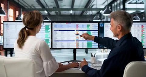 Medical Billing Analyst And Coder Reviews Spreadsheet Data On Dual Monitors. Foto stock