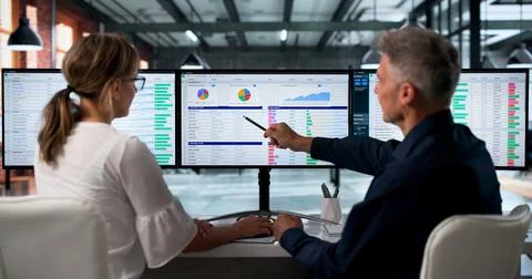 Medical Billing Analyst And Coder Reviews Spreadsheet Data On Dual Monitors A Foto stock