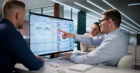 Medical Billing Analyst Reviews Coding Spreadsheets With Two Colleagues Colla Stock Photos