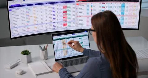 Medical Billing Analyst Studies Coding Data Carefully On Laptop At Office. Stock Photos