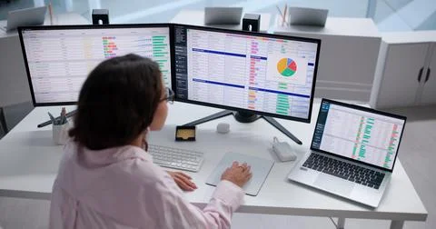 Medical Billing Coder Carefully Reviews Patient Bills Using Laptop Software. Stock Photos