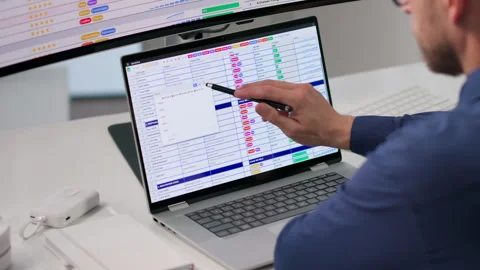 Medical Billing Coder Reviews Spreadsheet Data Using Laptop Stock Footage 347897573