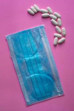 Medical blue protective mask and white tablets, capsules, pills or vitamins Stock Photos
