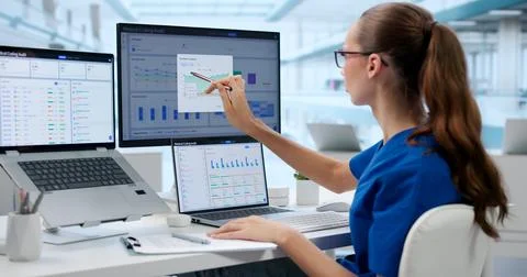 Medical Coder Checks Patient Records On Laptop For Accurate Billing. Stock Photos