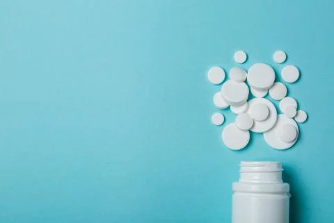 Medical concept - different shape white pills on blue background Stock Photos
