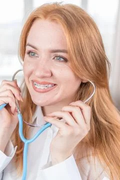 Medical concept. Smiling nurse with braces and a stethoscope in her hand. H.. Stock Photos