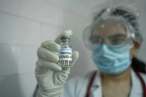 Medical doctor staring at covid 19 vaccine Stock Photos