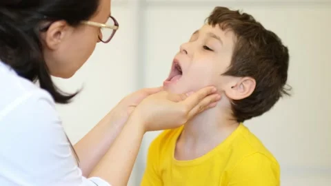 Medical examination. Pediatrician feels the tonsils in a child with a sore Stock Footage