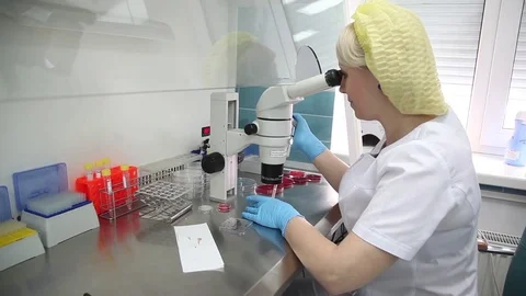 The medical lab. laboratory assistant looking at a large microscope.a blood test Stock Footage 75060168