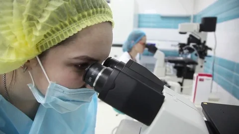 The medical lab. laboratory assistant looking at a large microscope.a blood test Stock Footage 75095314