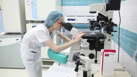 The medical lab. laboratory assistant looking at a large microscope.a blood test Stock Footage 75095754