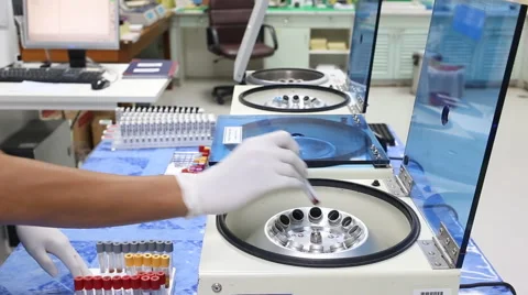 Medical lab technician loads centrifuge Stock Footage