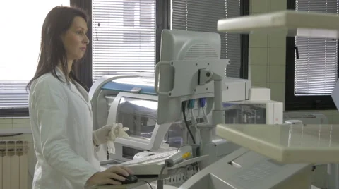 Medical laboratory technician loading data on computerized equipment, blood test Stock Footage 59112703