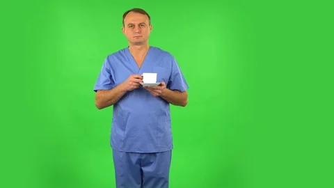 Medical man drinks unpalatable coffee and is disgusted. Green screen Stock Footage 123280245