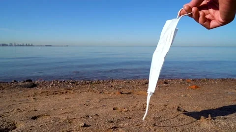 A medical mask in the hand of a person develops in the wind against 動画素材 131609436