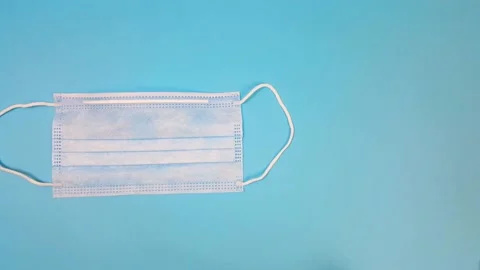 Medical masks move on the table until they are stopped by a thermometer. Various Stock Footage 144290487