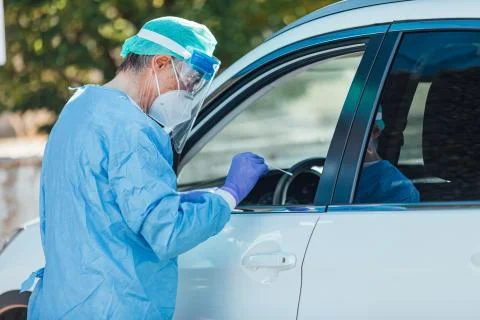 Medical personnel wearing a PPE, performing PCR on a patient inside the car t Stock Photos