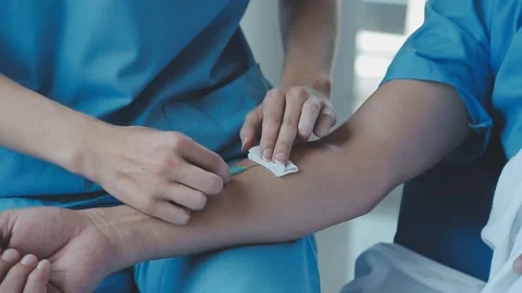 Medical procedure with needle injection in the arm for medical treatment Stock Footage 325445541