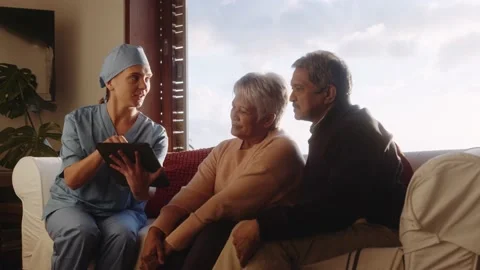 Medical professional explaining diagnosis to elderly couple in their home on Video stock 165241789