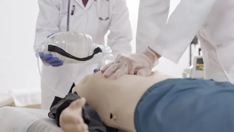 Medical professional performing procedure CPR on mannequin with oxygen mask 스톡 동영상 270174103