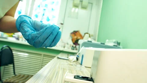 Medical professional quickly inserting diagnostic strip into reader Stock-Footage 333989371