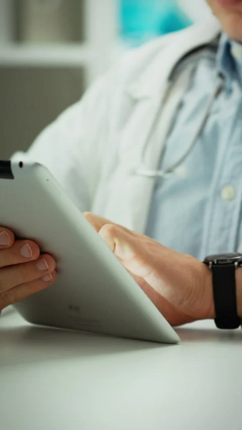 Medical professional using tablet device in a clinical setting to manage pat Stock Footage 331667386