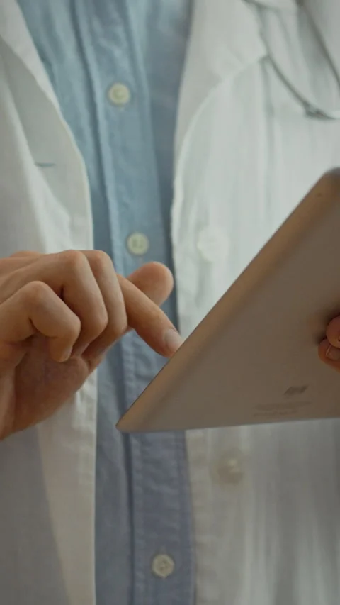 Medical professional using a tablet for patient care in a clinical setting Stock Footage 331667357