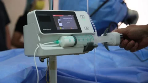 Medical professionals preparing and using infusion pump in operating room Stock Footage 316399579