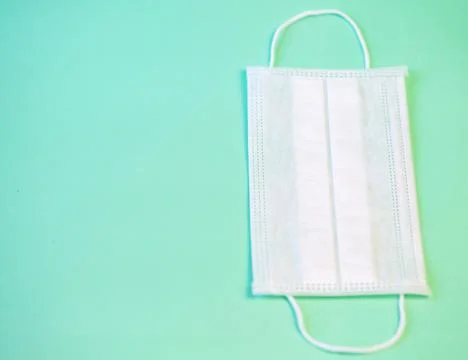 Medical protective face mask on a solid turquoise background 库存照片